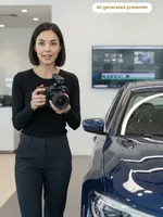 Sage holding a camera next to a car in a showroom